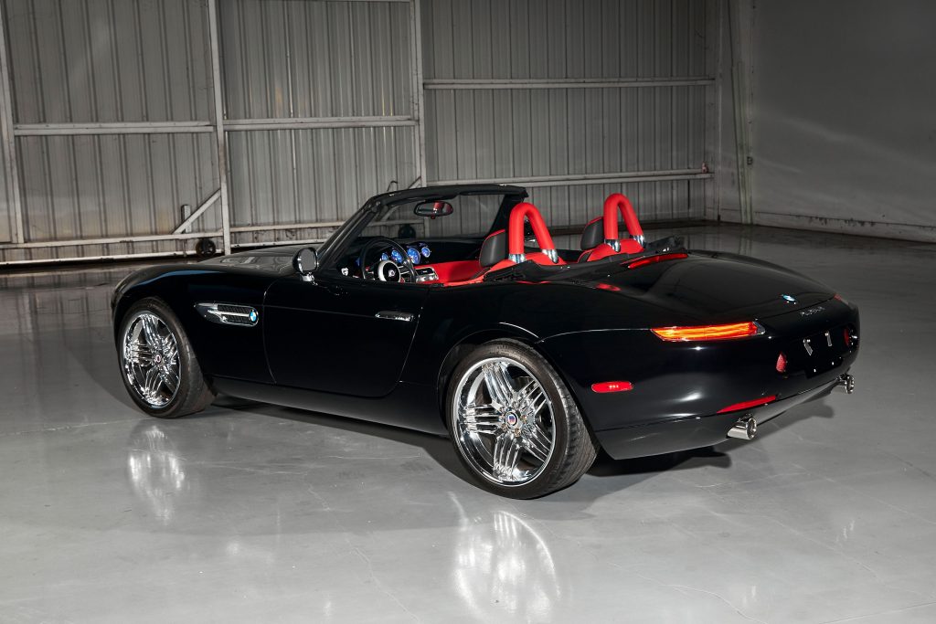 The rear 3/4 view of a black 2003 BMW Alpina Z8 Roadster with a red-leather interior
