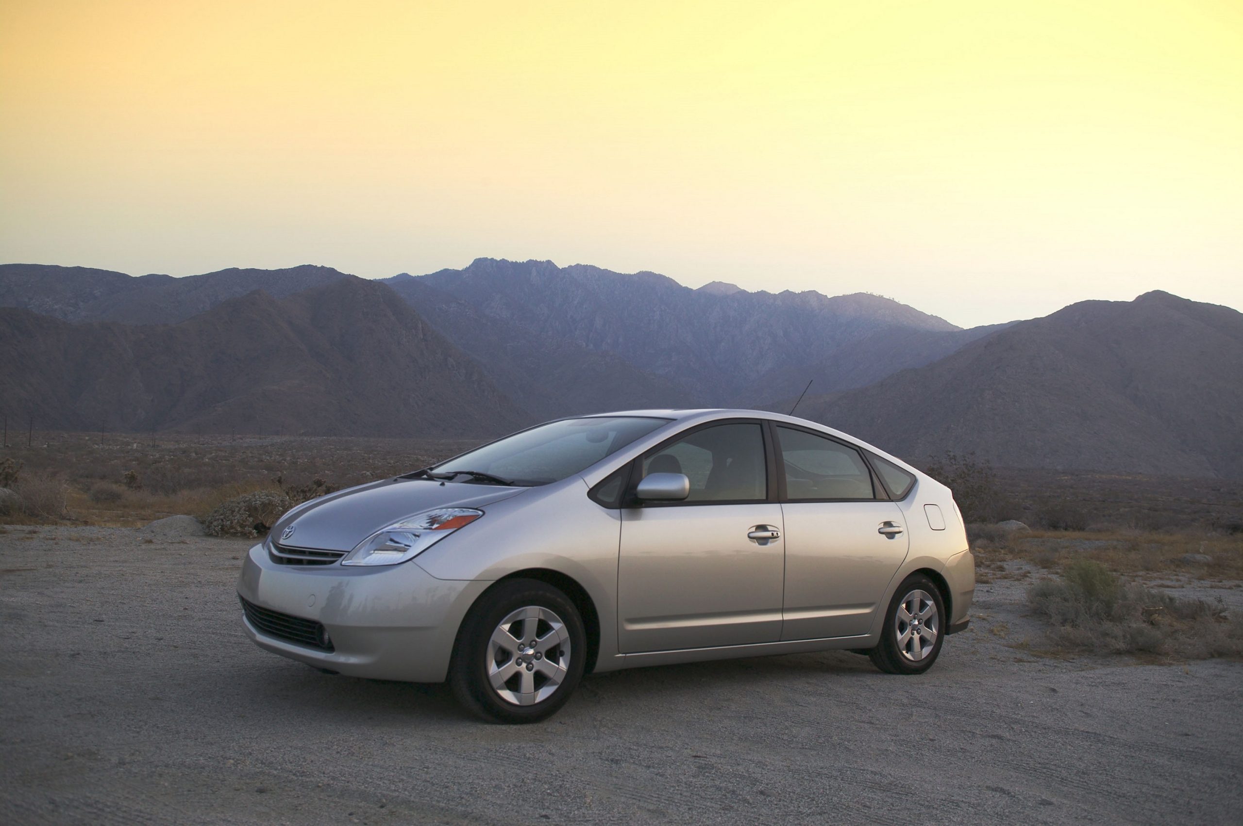 A silver Toyota Prius shot in the Angeles forest from the front 3/4 angle at sunset
