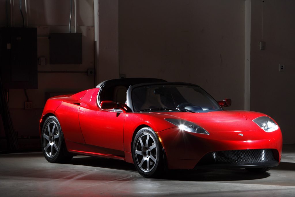 A red 2008 Tesla Roadster in a warehouse