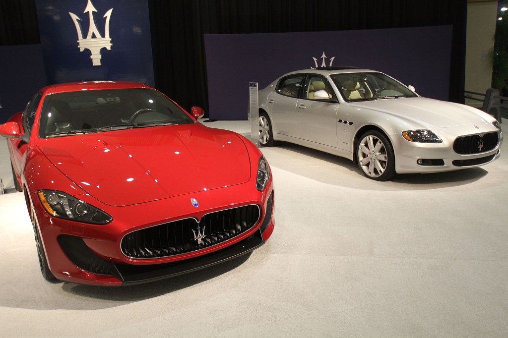 A red 2012 Maserati GranTurismo MC next to a silver 2012 Quattroporte at the Miami International Auto Show