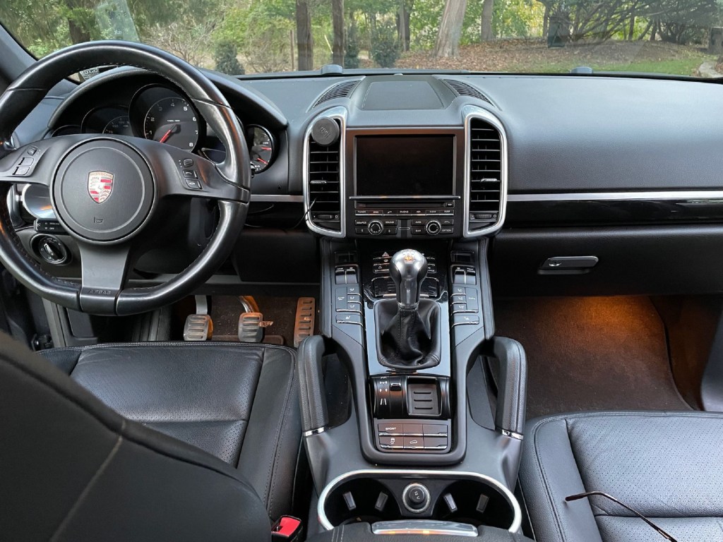 The black dashboard and black-leather front seats in a 2012 Porsche Cayenne