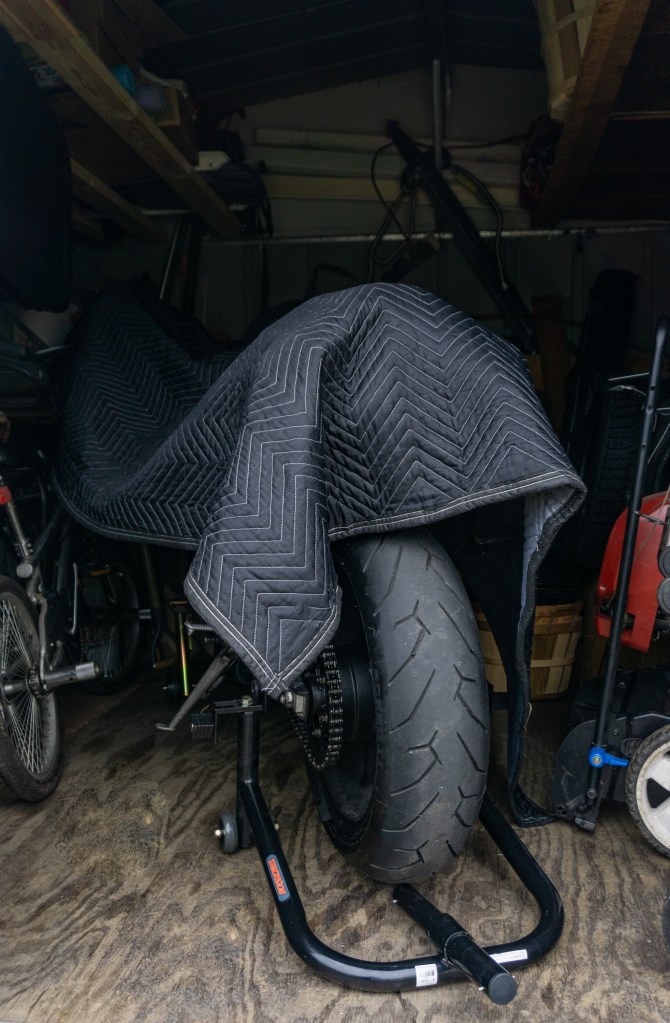 A 2012 Triumph Street Triple R motorcycle covered in winter storage