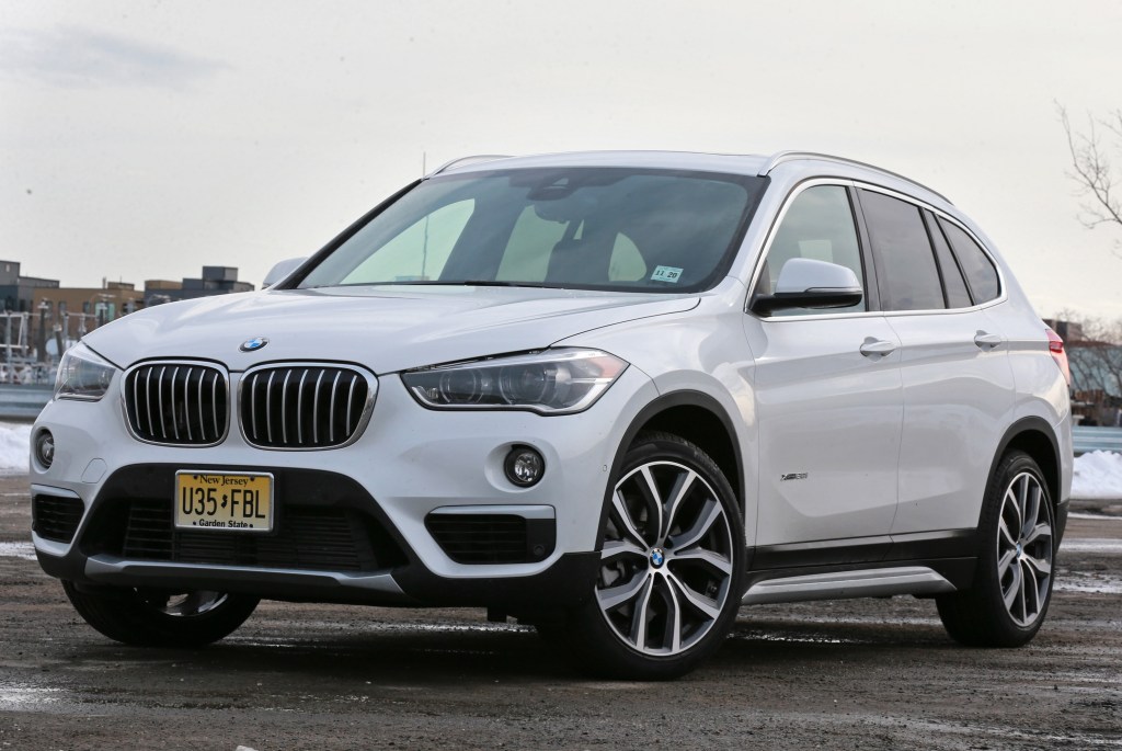 A white 2016 BMW X1 xDrive 28i parked in a gravel lot