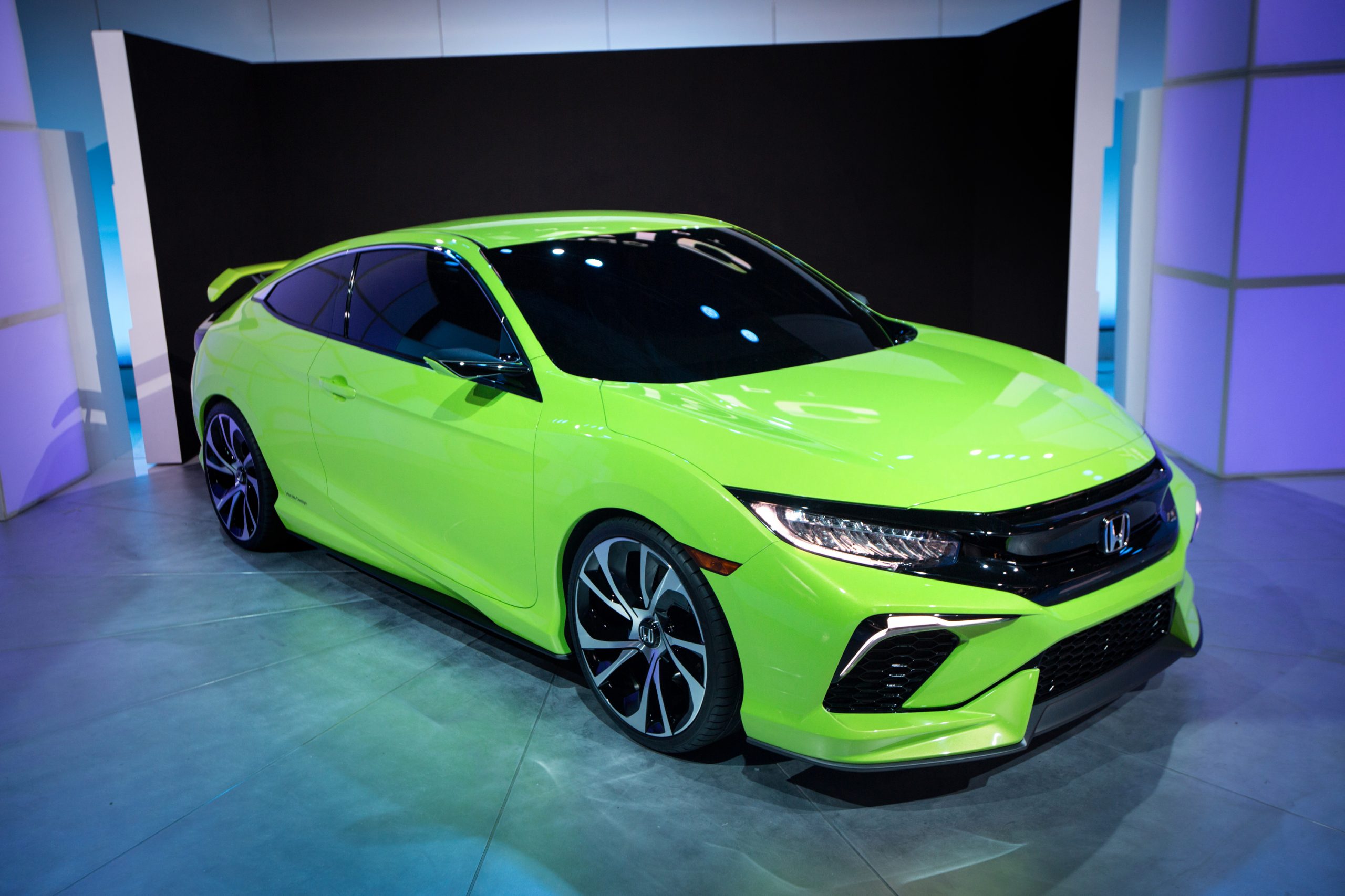 A green Honda Civic coupe shot from the 3/4 angle at an auto show