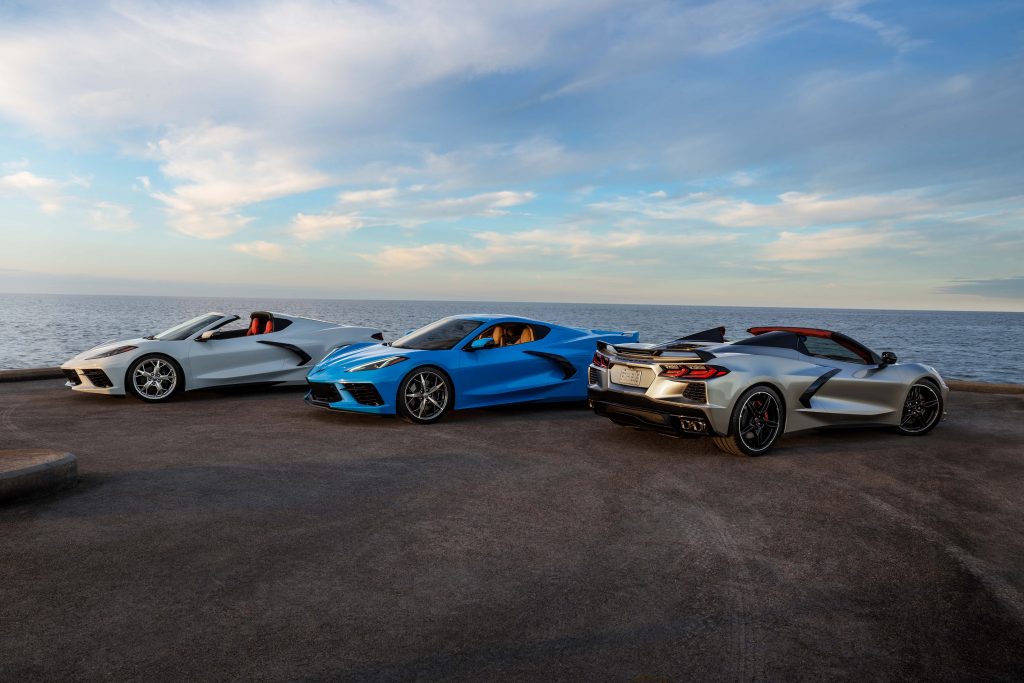A blue 2021 Chevrolet Corvette Stingray Coupe in-between two silver Convertibles overlooking the ocean