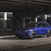 A 2021 Mercedes-Benz AMG GLB SUV with a blue paint color option parked under a concrete highway overpass