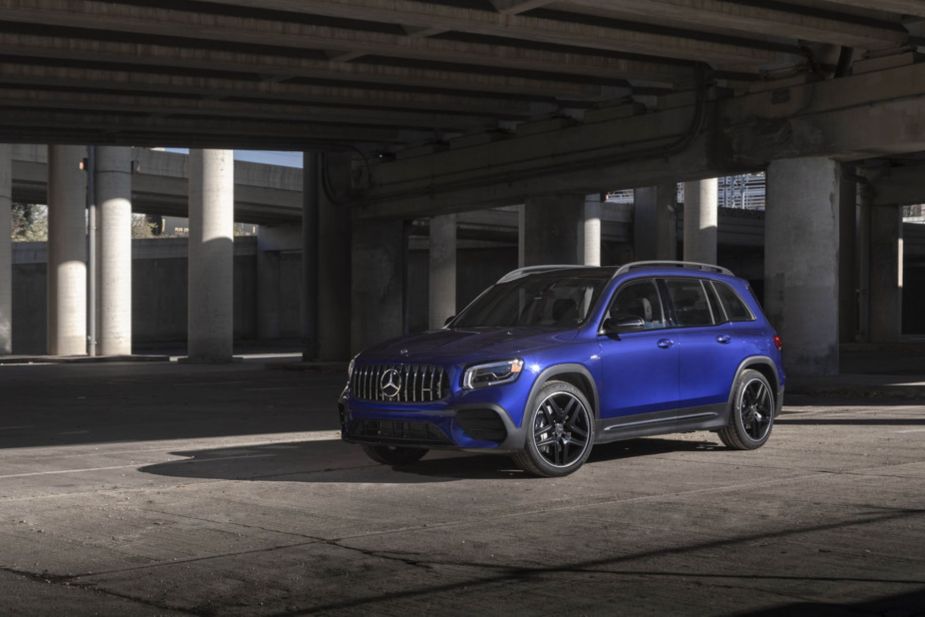 A 2021 Mercedes-Benz AMG GLB SUV with a blue paint color option parked under a concrete highway overpass
