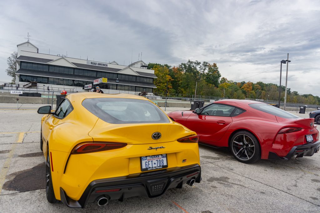 The rear view of a red 2021 Toyota GR Supra 3.0 Premium next to a yellow 2021 Toyota GR Supra 2.0