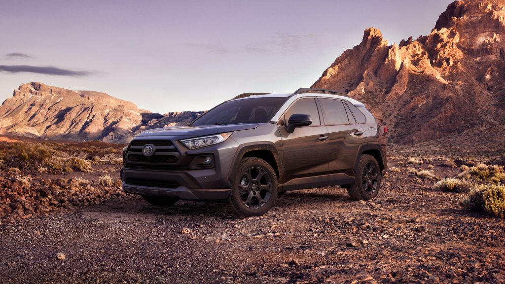 A gray 2021 Toyota RAV4 parked on dirt ground, it crushes the Ford Escape in most ways, according to U.S. News.