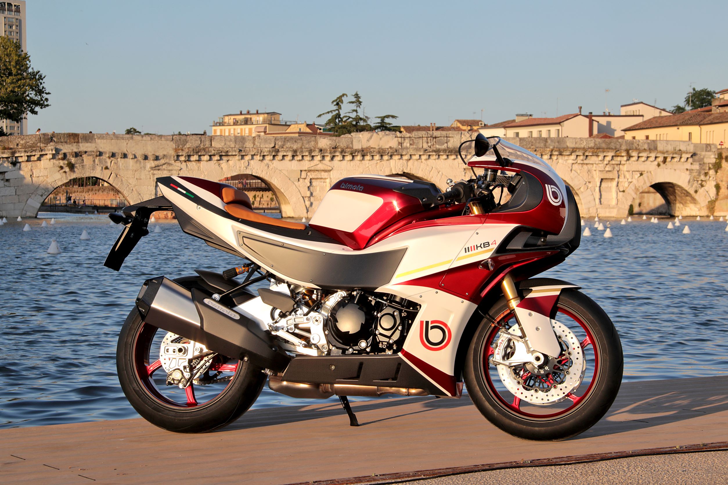 The side view of a red-and-white 2022 Bimota KB4 on a dock