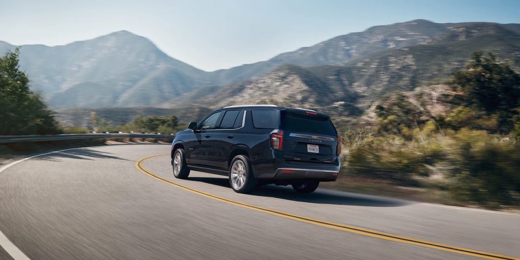 A black 2022 Chevy Tahoe SUV drives on a road, it just got a new transmission.