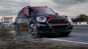 A black and red 2022 Mini Countryman driving down a road.
