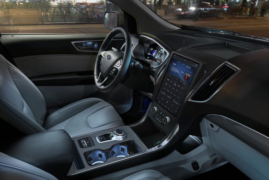 The interior of a 2022 Ford Edge ST at night, is the midsize crossover SUV better than the Chevy Blazer RS?
