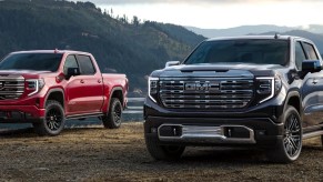Two 2022 GMC Sierra 1500s parked in front of a lake.