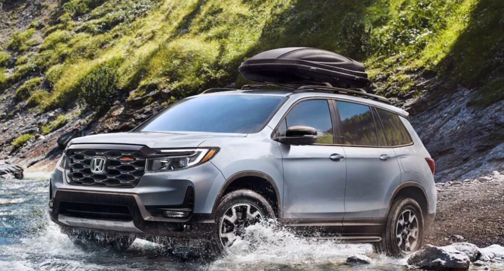 A gray 2022 Honda Passport TrailSport is driving in shallow water. 