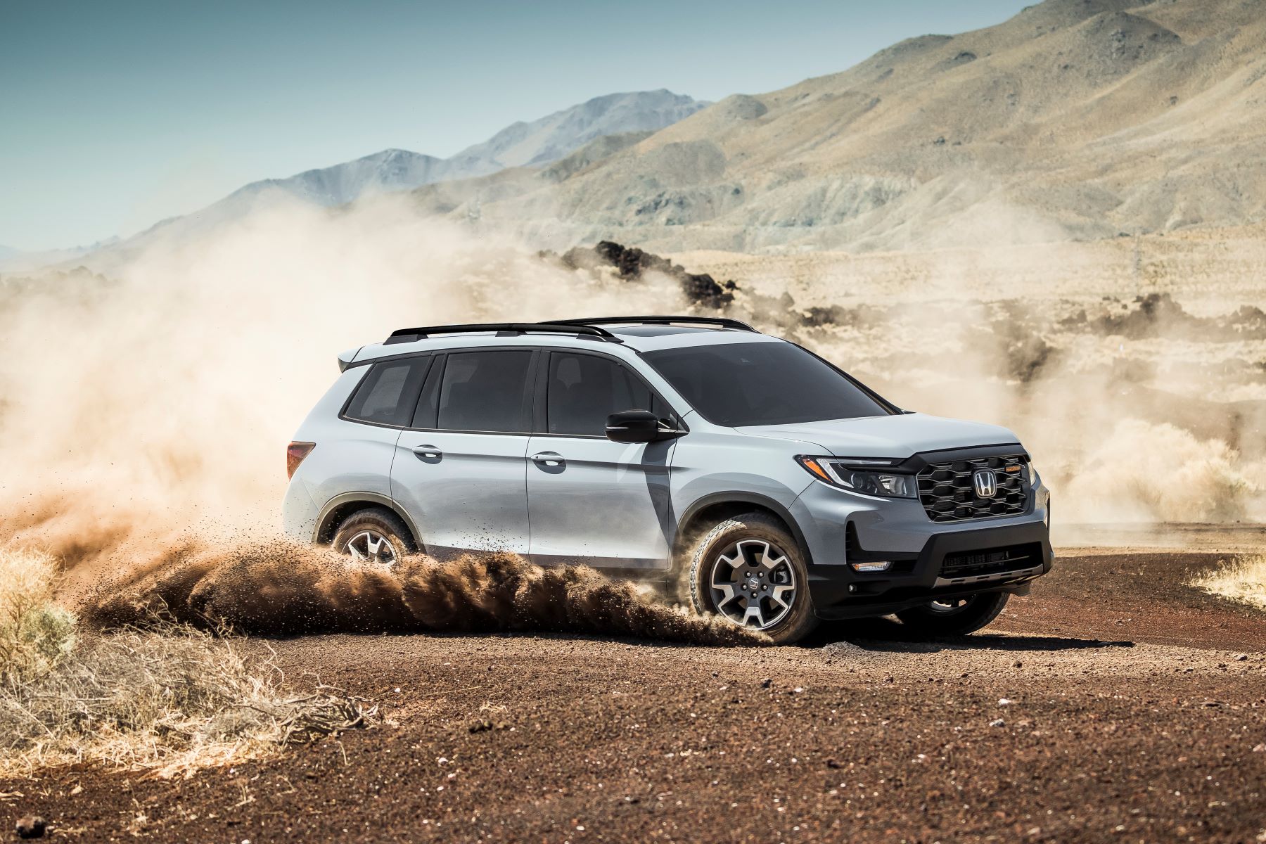 The 2022 Honda Passport TrailSport compact adventure SUV driving through dirt plains in the country