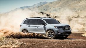 The 2022 Honda Passport TrailSport compact adventure SUV driving through dirt plains in the country