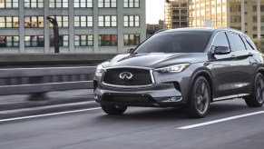 A gray 2022 Infiniti QX50 driving on a road, it gained new tech upgrades for the new model year.