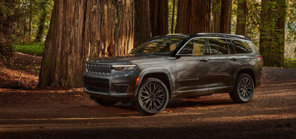 A 2022 Jeep Grand Cherokee L midsize crossover SUV parked in the middle of a forest