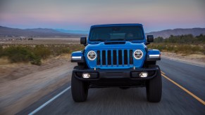 Front view of a blue 2022 Jeep Wrangler Rubicon 392 traveling on a desert road