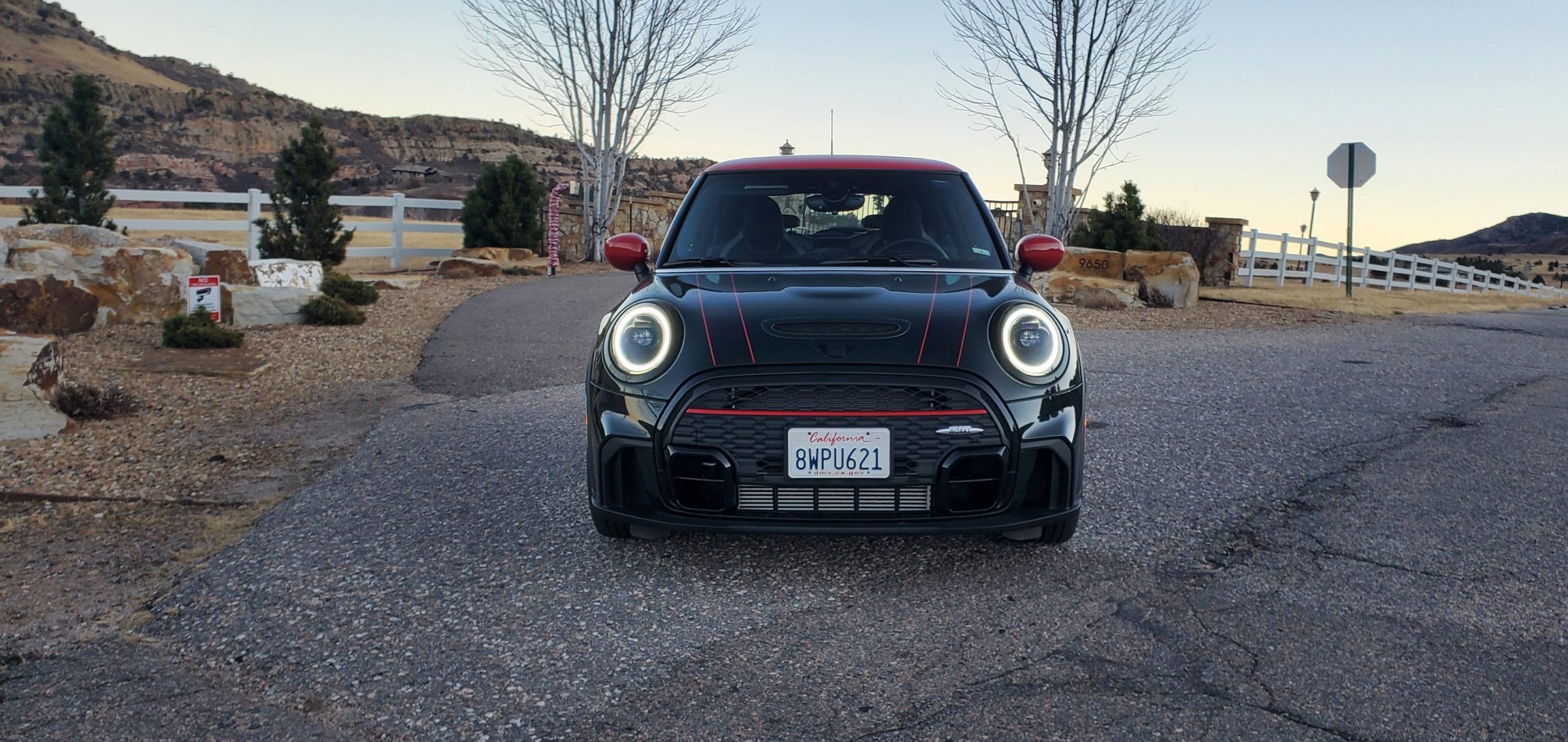 A front shot of a racing green 2022 Mini Cooper JCW at dusk in the Rockies
