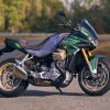 A green-and-silver 2022 Moto Guzzi V100 Mandello parked on a curving road