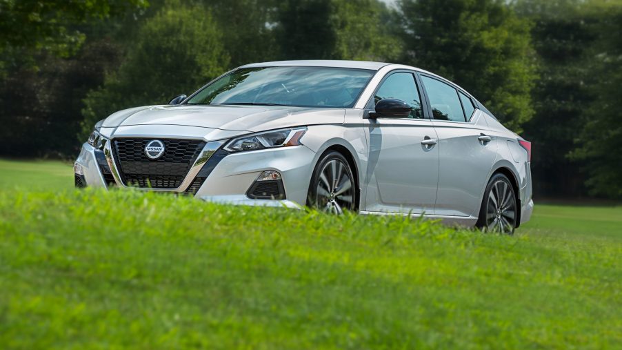 A silver 2022 Nissan Altima sedan shot from the front 3/4 on a grassy hill
