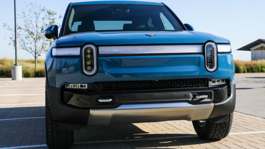 A blue 2022 Rivian R1T electric pickup truck is parked.
