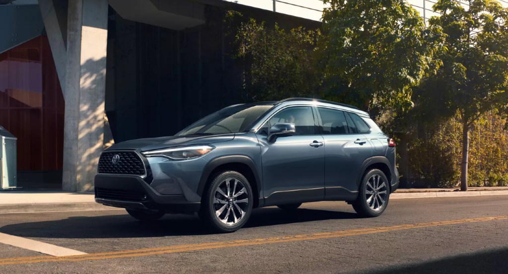 A blue 2022 Toyota Corolla Cross is driving on the road.