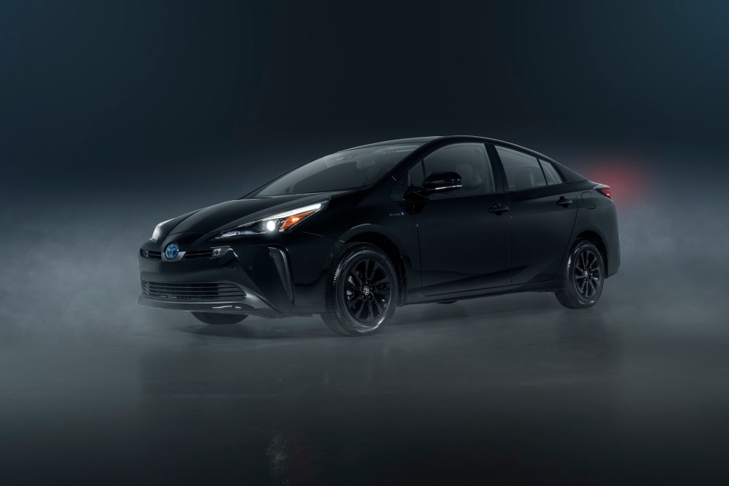 A black Toyota Prius hybrid shot through light fog in a photo booth from the 3/4 angle