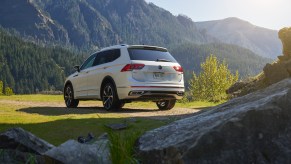 A white 2022 Volkswagen Tiguan sits on grass with a mountainous background, what is the release date, price, and specs for the SUV?