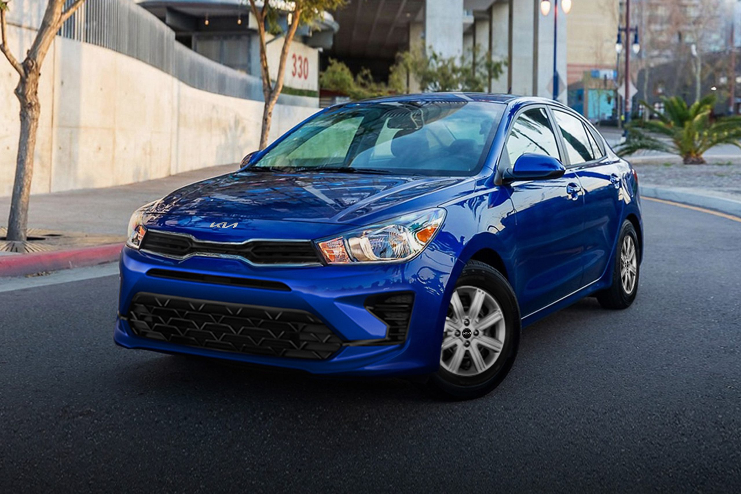 A blue 2022 Kia Rio shot from the front 3/4 on a city street