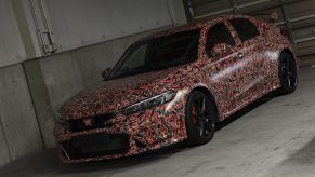 A camouflaged 2023 Honda Civic Type R in a pit lane garage at Suzuka