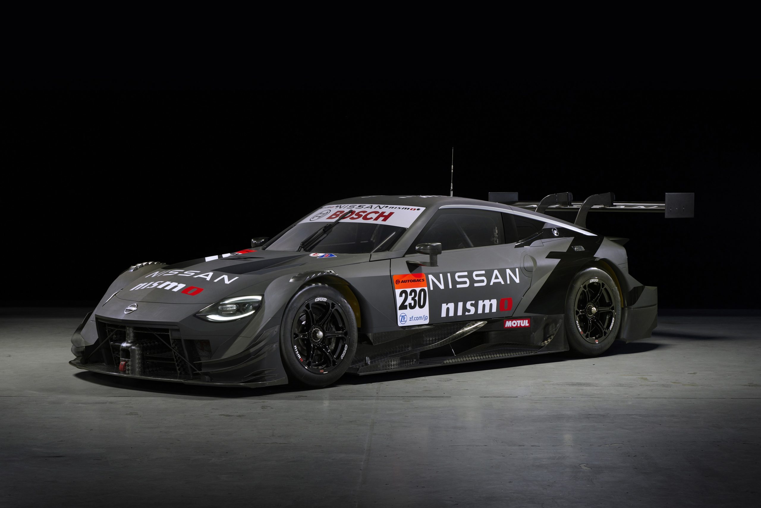 A black 2023 Nissan Z race car shot in a photo booth from the 3/4 angle