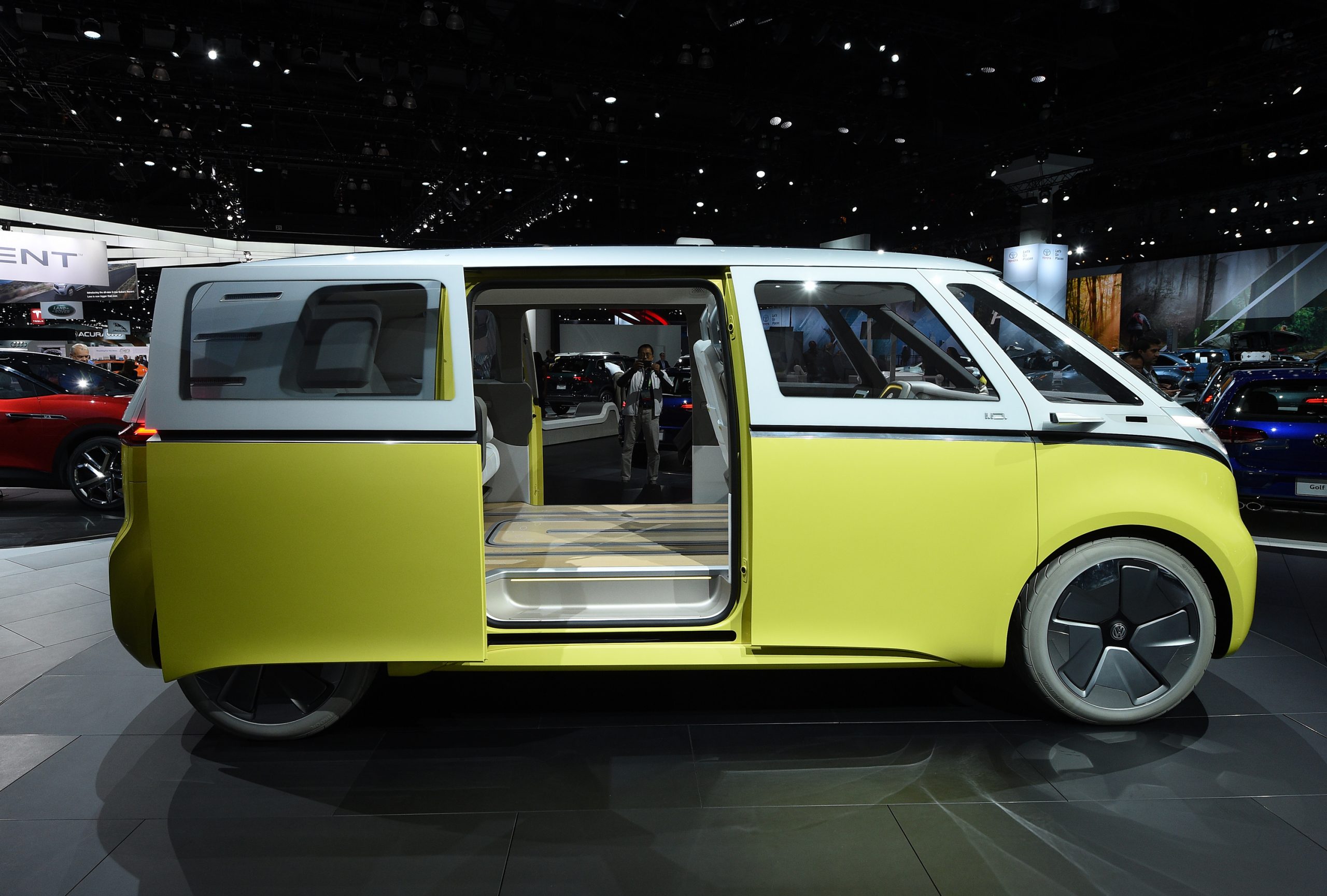 A yellow and white 2024 Volkswagen ID.Buzz electric minivan displayed at the LA Auto Show in 2017
