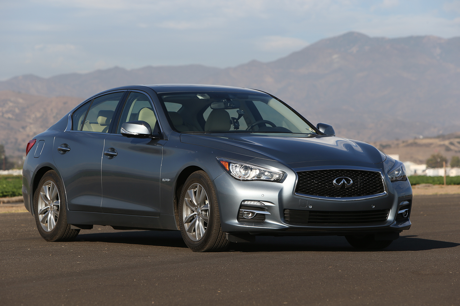 A grey Infiniti Q50, an excellent cheap luxury car shot from the front 3/4 angle 