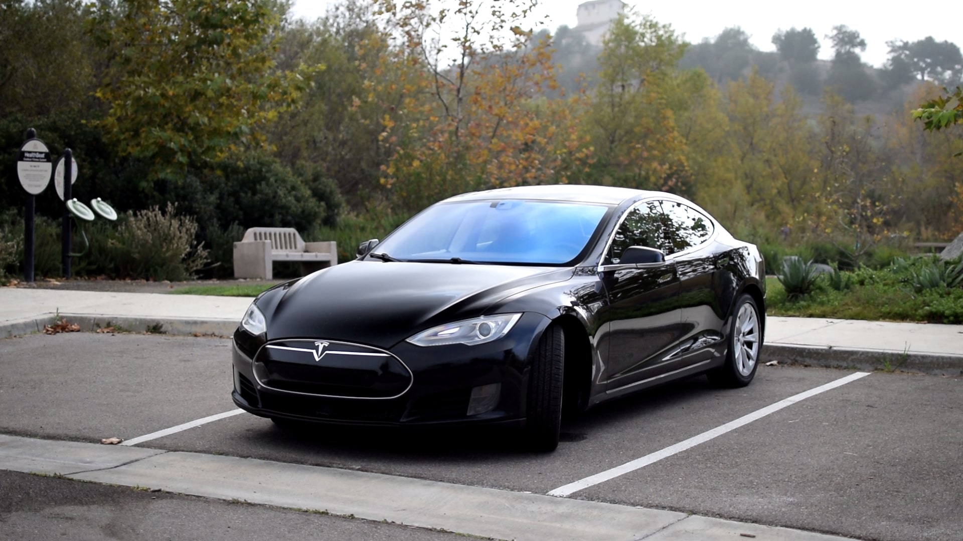 A black Tesla Model S EV sedan shot from the front 3/4 angle