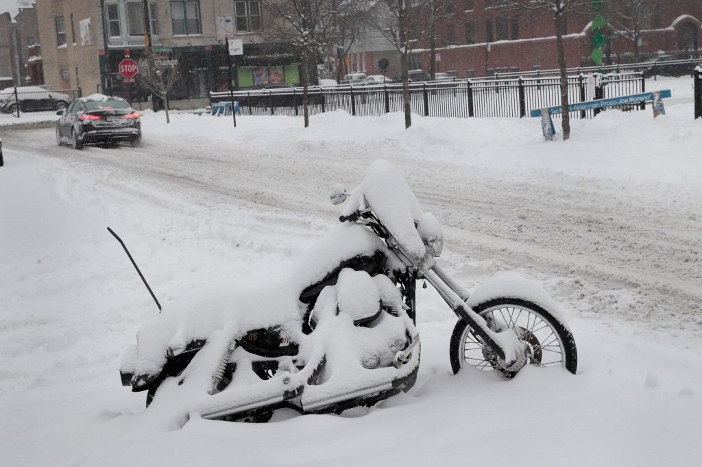 A snow-covered motorcycle in a 2018 Chicago winter on the street
