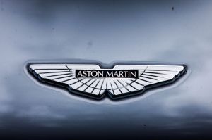 A silver Aston Martin logo on a grey car. 