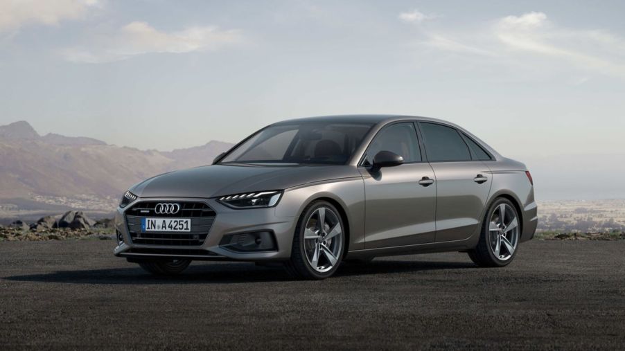 The Audi A4 Sedan luxury executive car parked on a dirt lot with mountains and fog in the background