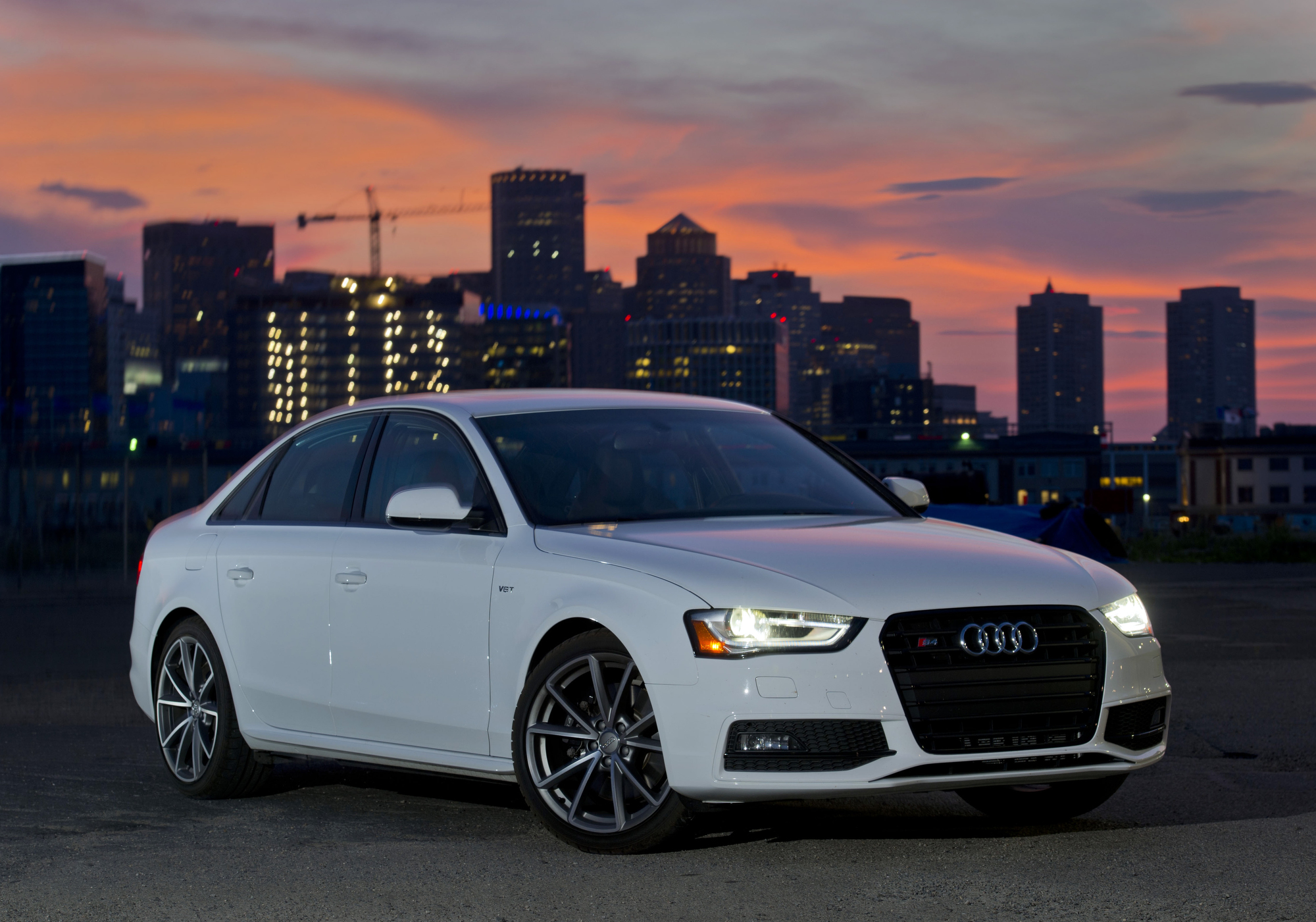 A white Audi S4 shot from the front 3/4 at sunset