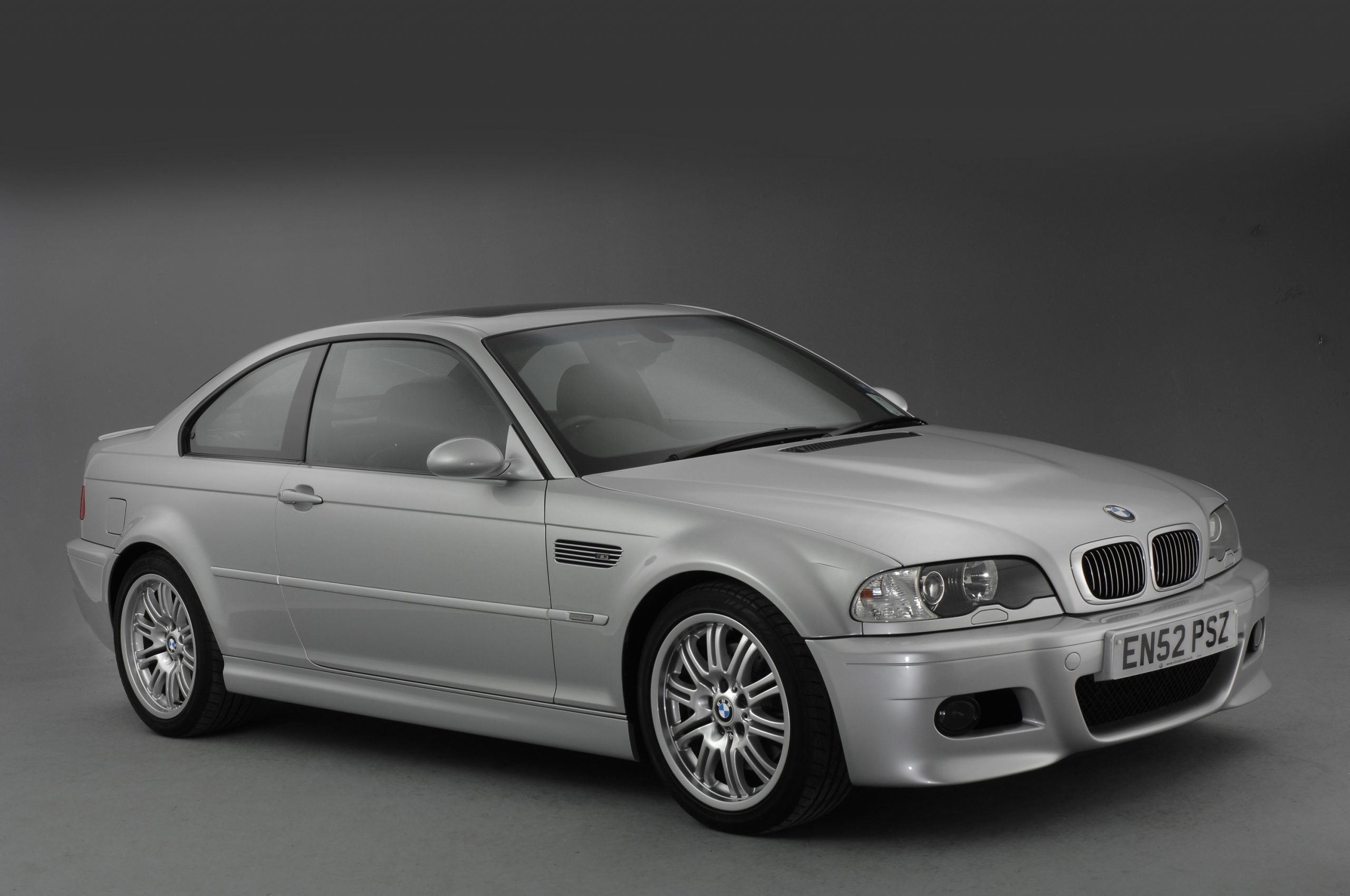 A silver E46 M3 shot from the 3/4 angle in a photo studio