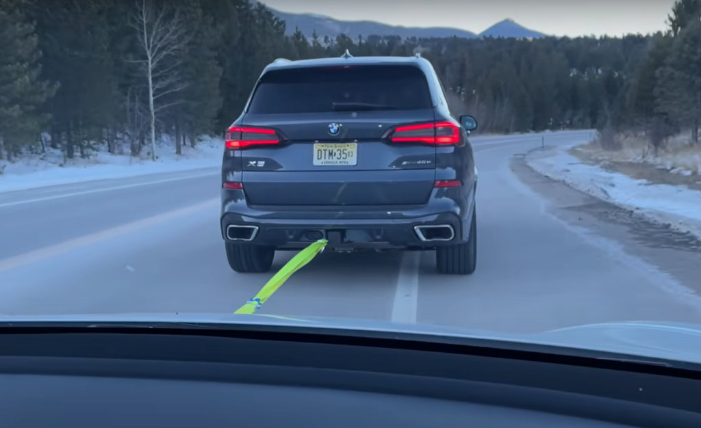 BMW X5 PHEV tow charging a Tesla Model 3 on a Colorado mountain road