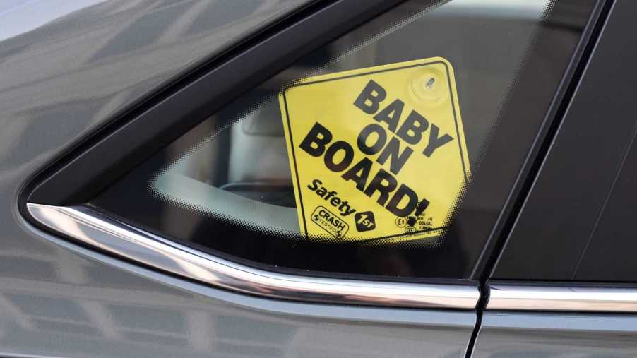 Baby on Board sign hanging from a car window