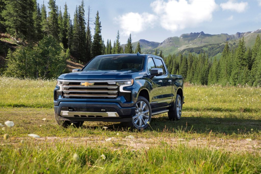 Blue 2022 Chevy Silverado 1500 parked in a field, with a Consumer Reports reliability rating of 1 out of 5