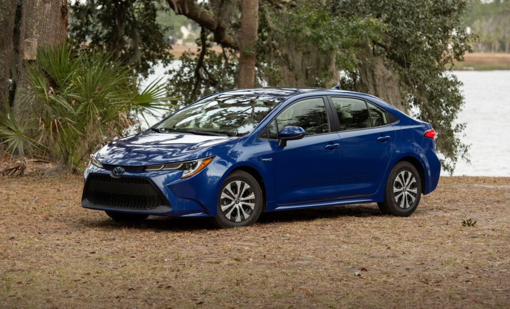 Blue 2022 Toyota Corolla Hybrid, a good non-electric car to save money on gas, parked near a lake