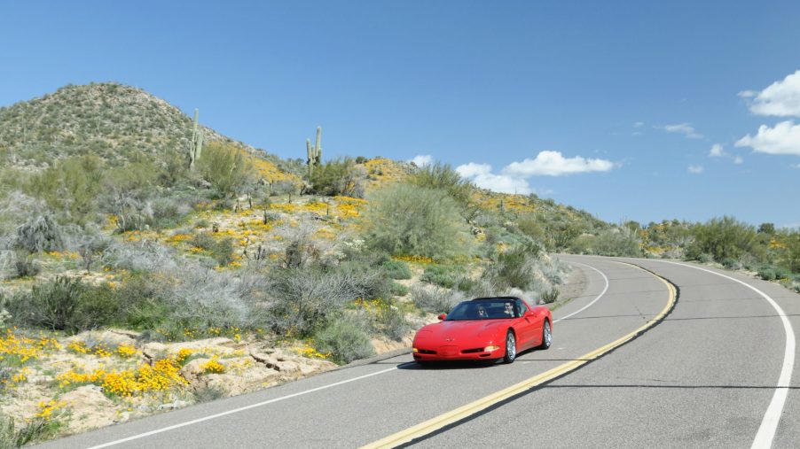 A red C5 Chevrolet Corvette sports car on a back road