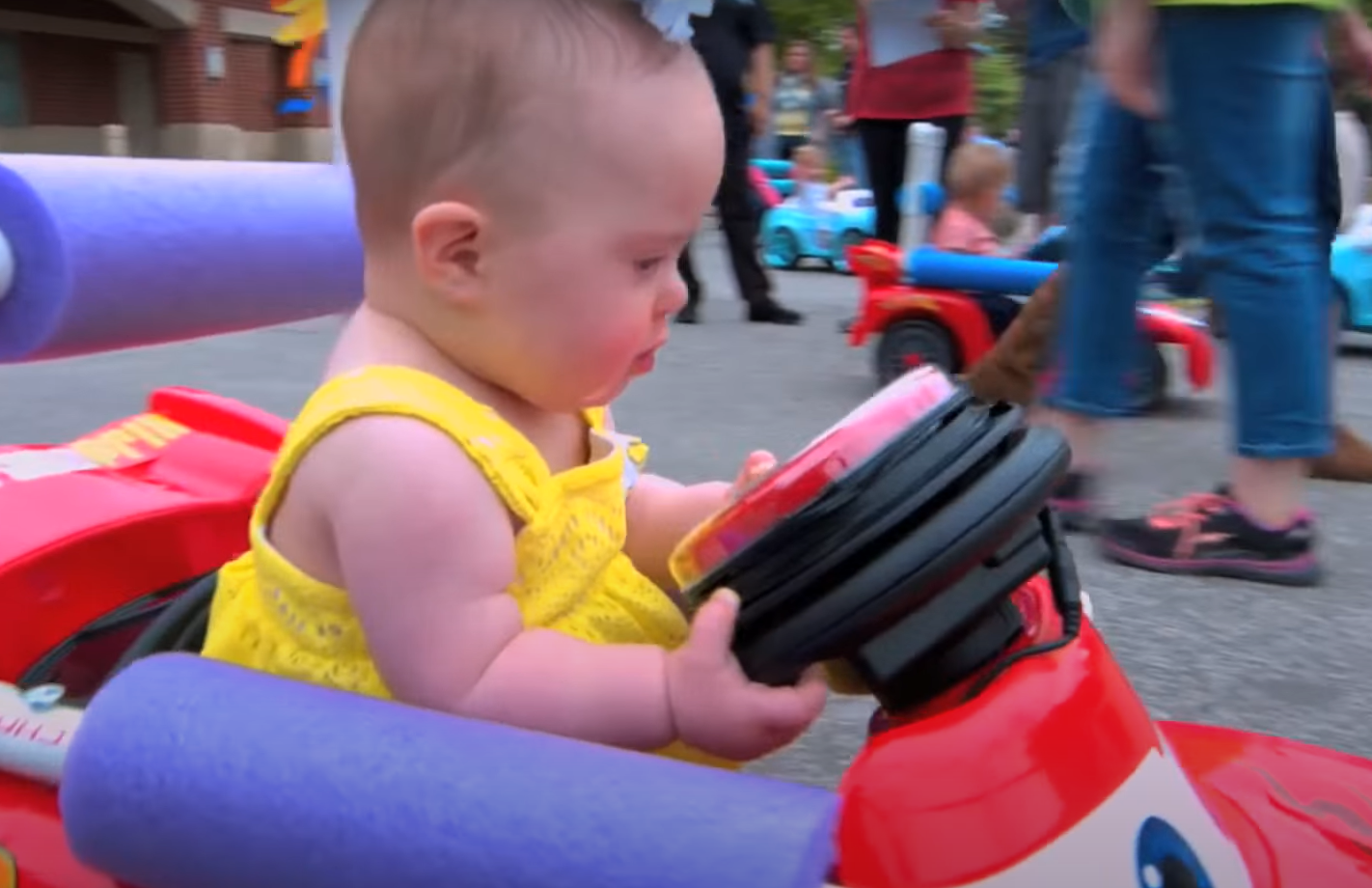 Kid with mobility disability driving a custom Go Baby Go toy car