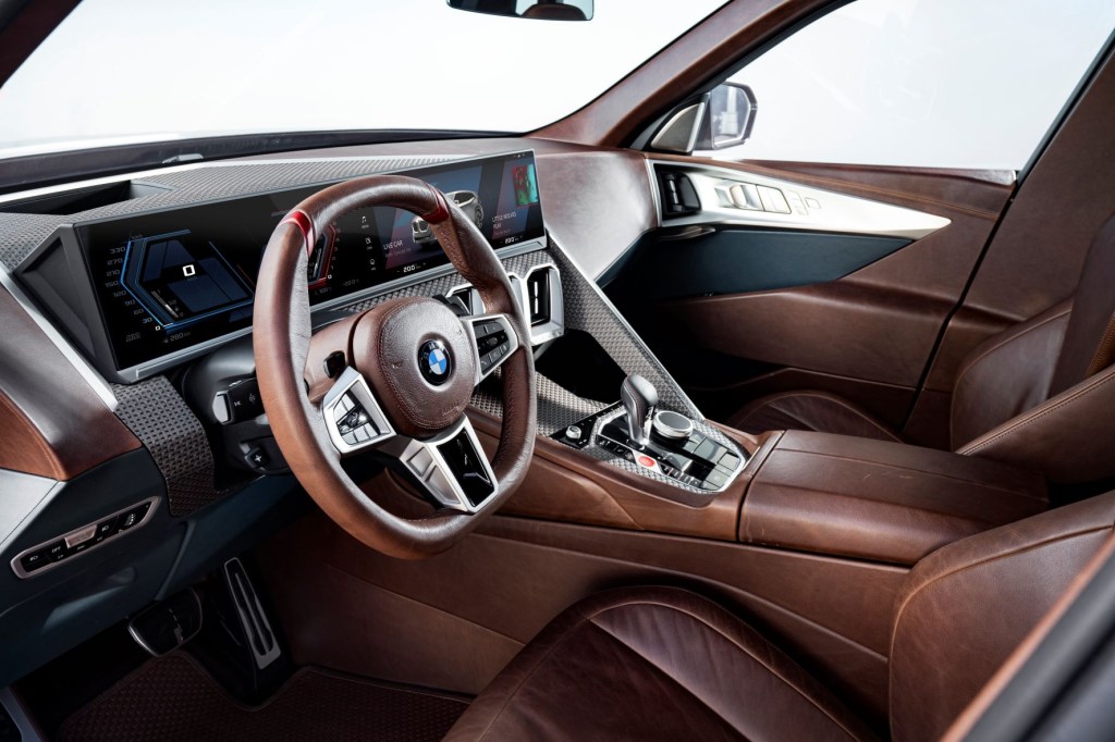 Dashboard, infotainment system, steering wheel, and leather front seats in 2023 BMW XM. Leather seats is the most popular new car feature.  