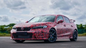 Driver's side front angle view of redesigned 2023 Honda Civic Type R wrapped in camouflage